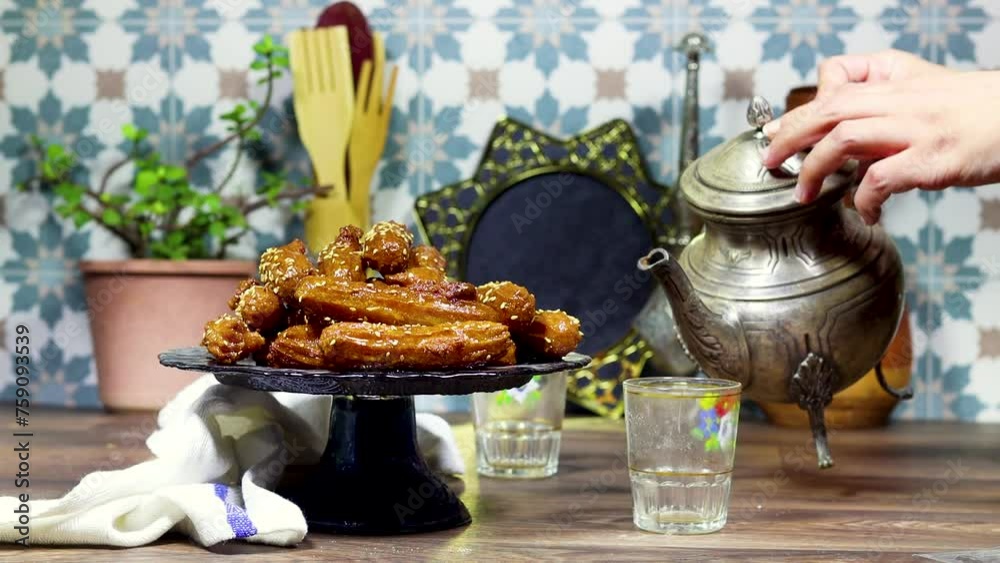 algeria oriental Balah el sham dessert fritters named zlabiat al banan in algerian language with arabic tea and woman pours hot tea from arabic teapot