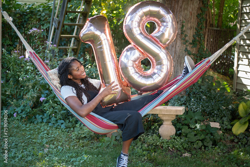 Teen with 18th birthday balloons