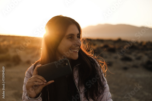 happy brunette woman using her phone photo