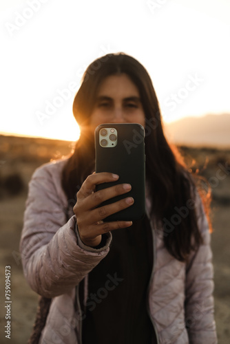 happy brunette woman using her phone photo
