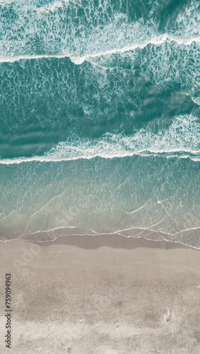 Vertical video of Drone aerial view of paradise beach. Turquoise sea water and clear sand at sunset. photo