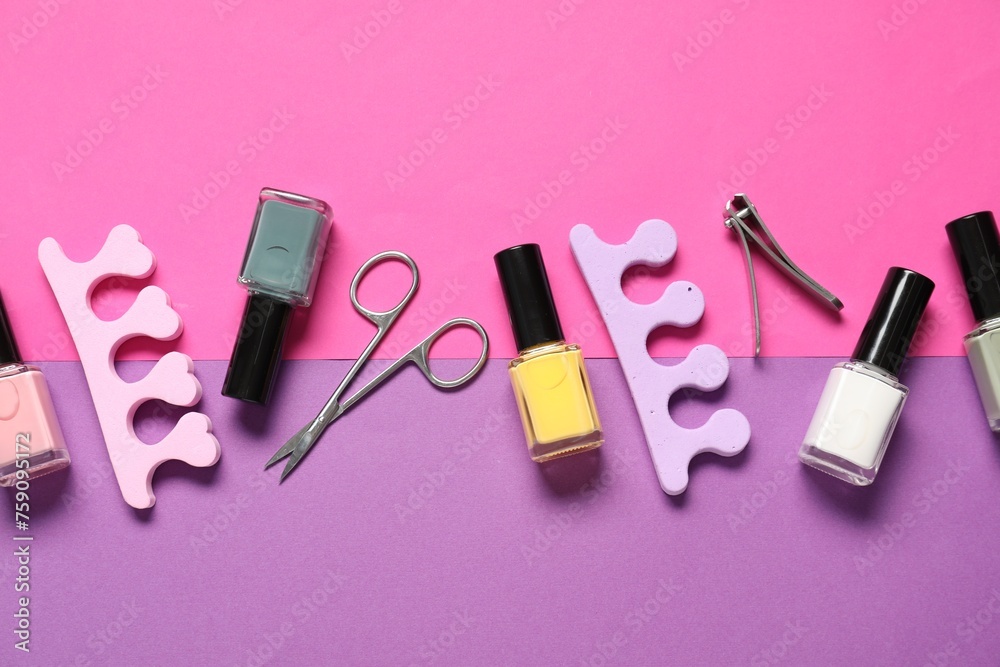 Nail polishes, clippers, scissors and toe separators on color background, flat lay Nail polishes, clippers, scissors and toe separators on color background, flat lay