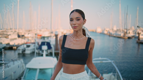 Beautiful model posing harbor with seductive smile close up. Brunette on pier