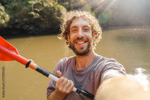 Selfie of man kayaking among islands covered in jungles at sunset  photo