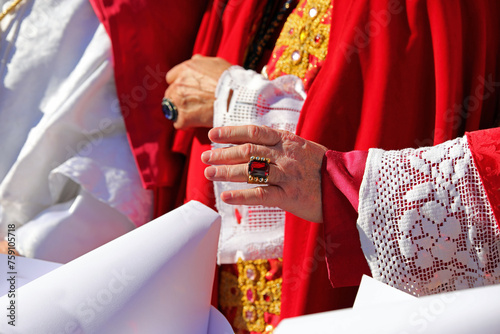 Bishop in resplendent red vestments blesses congregation photo