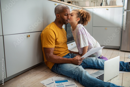 Daughter comforting father during financial crisis in the kitchen photo