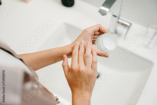 Hands while applying the cream photo