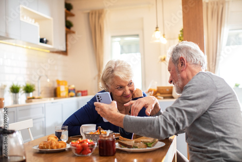 Elderly couple having breakfast in the kitchen photo