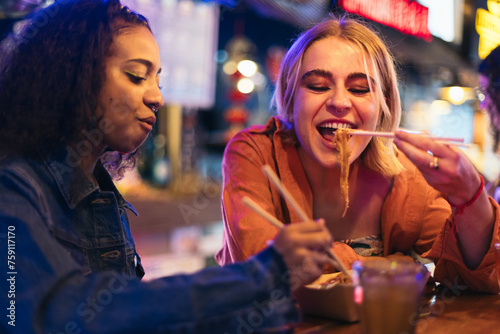 Young women in a date having dinner at a street market photo