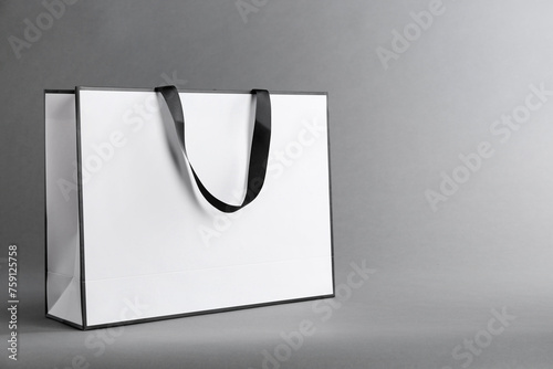 One paper bag on grey background, space for text. Mockup for design