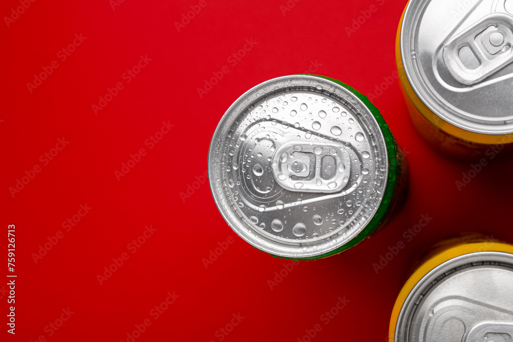 Energy drinks in wet cans on red background, top view. Space for text Energy drinks in wet cans on red background, top view. Space for text
