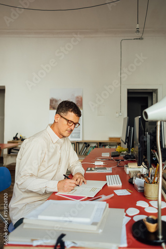 Man writing in office photo