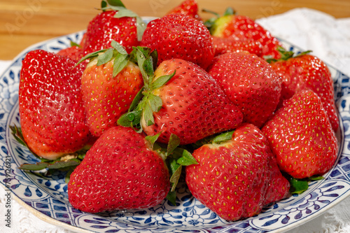New harvest, plate with bio ripe red sweet strawberry from Spain