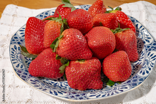 New harvest, plate with bio ripe red sweet strawberry from Spain