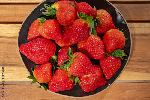 New harvest, plate with bio ripe red sweet strawberry from Spain