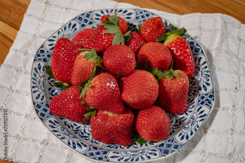 New harvest, plate with bio ripe red sweet strawberry from Spain
