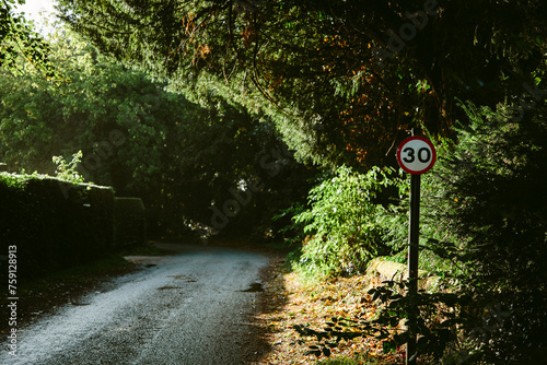 A speed sign on a country road photo