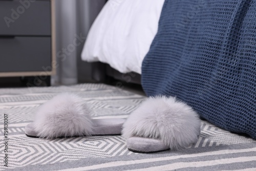 Grey soft slippers on carpet indoors, closeup