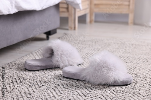 Grey soft slippers on carpet at home