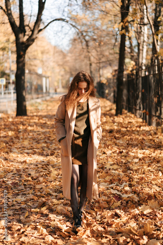 Red-haired girl walking in autumn outdoors.