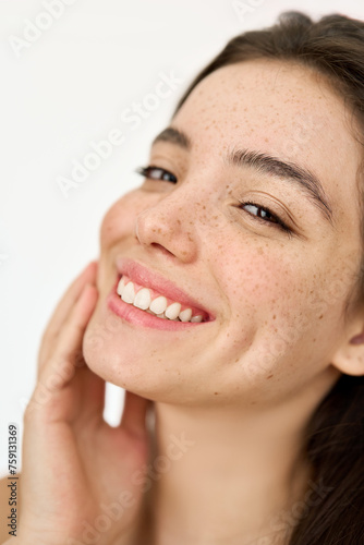 Happy Latin girl model with freckles on face looking at camera isolated on white background advertising skin care promo, skincare cosmetic dermatology treatment, beauty vertical close up portrait.