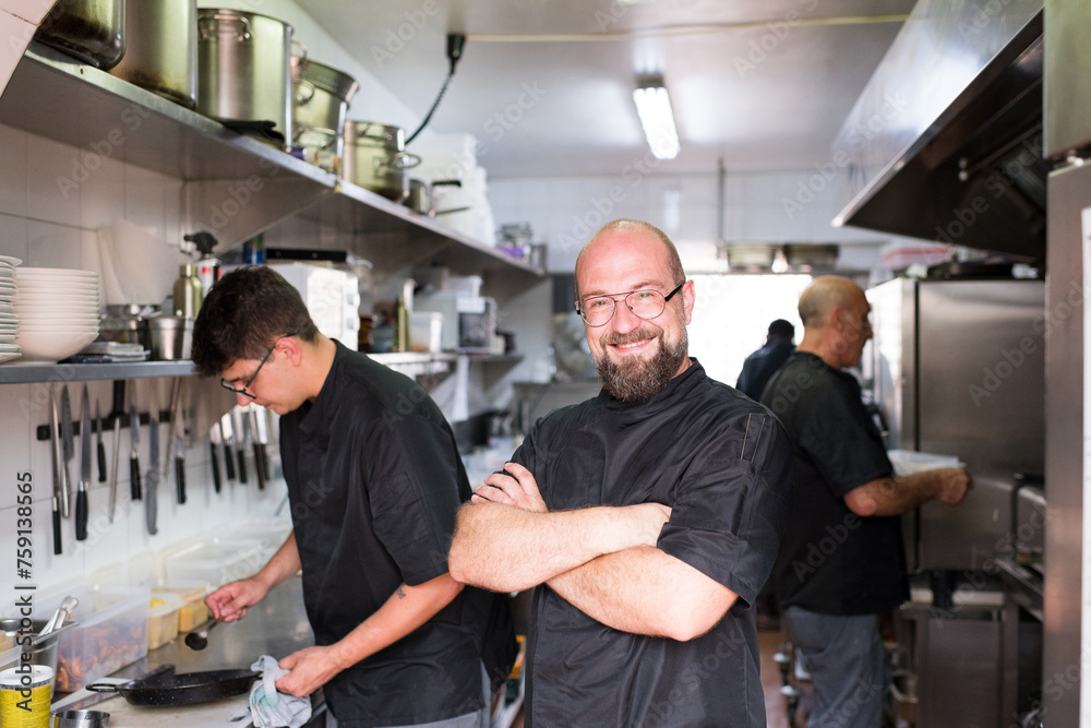 Smiling chef proud of his team at restaurant kitchen Smiling chef proud of his team at restaurant kitchen