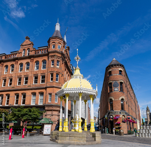 exterior facade of Bittles Bar next to The Jaffe Memorial Fountain located in Victoria Square, the shopping center and the flatiron and the Albert Memorial Clock, Belfast, Northern Ireland.