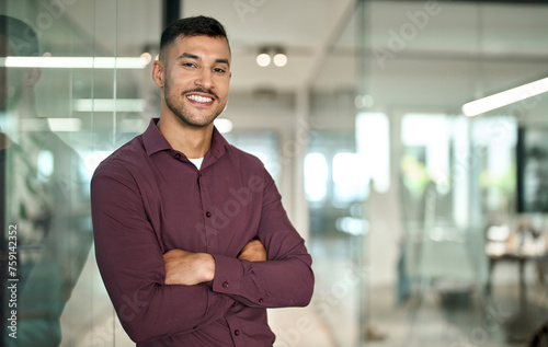 Foto Confident young smiling Latin business man leader looking at camera standing arms crossed in office