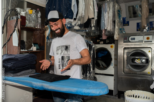 Smiling Middle Eastern Laundry Owner Enjoys His Work. photo