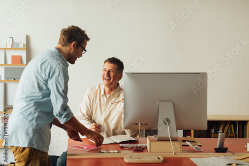 Laughing colleagues working in office photo