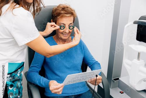 Crop woman doctor using lens in trial frame on client