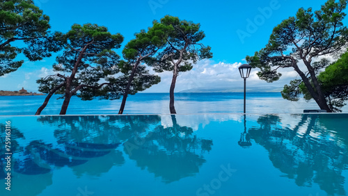 Obraz na płótnie Infinity pool in luxury hotel along the promenade in coastal town Makarska, Split-Dalmatia, Croatia, Europe. Coastline of Makarska Riviera, Adriatic Sea. Dreamlike atmosphere. Vacation summer concept w salonie