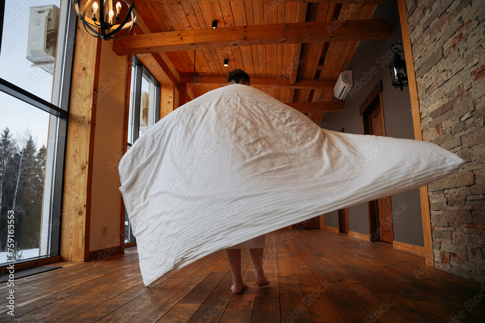 A woman is spinning wrapped in a blanket in her house A woman is spinning wrapped in a blanket in her house