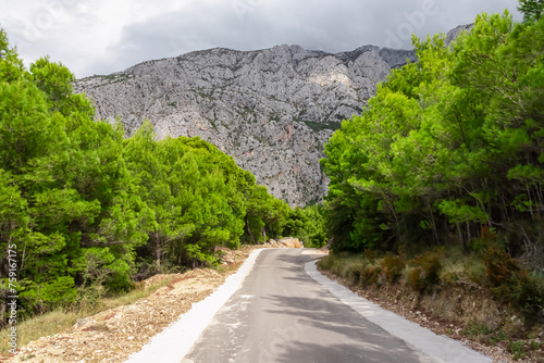 Scenic view of ancient fortress build into massive rock formation in village Kotisina near Makarska, Split-Dalmatia, Croatia, Europe. Hiking in Biokovo nature park in mountain of Dinaric Alps, Balkan photo