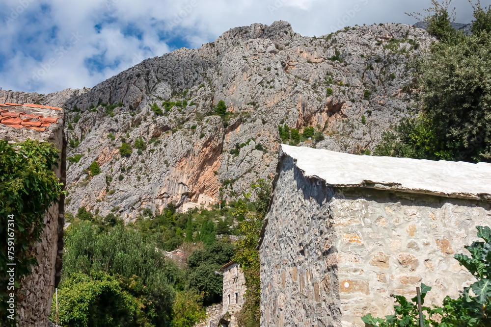 Scenic view of ancient fortress build into massive rock formation in village Kotisina near Makarska, Split-Dalmatia, Croatia, Europe. Hiking in Biokovo nature park in mountain of Dinaric Alps, Balkan