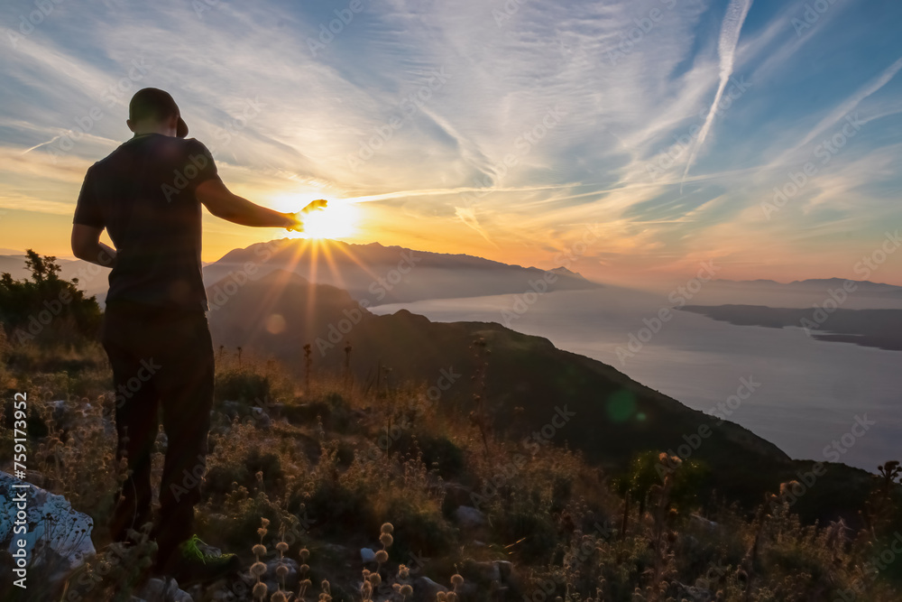 Fototapeta premium Hiker man with scenic sunrise view from top of mount Kula near Omis, Dinara mountains, Split-Dalmatia, Croatia, Europe. Coastline of Makarska Riviera, Adriatic Sea. Balkans in summer. Biokovo mountain