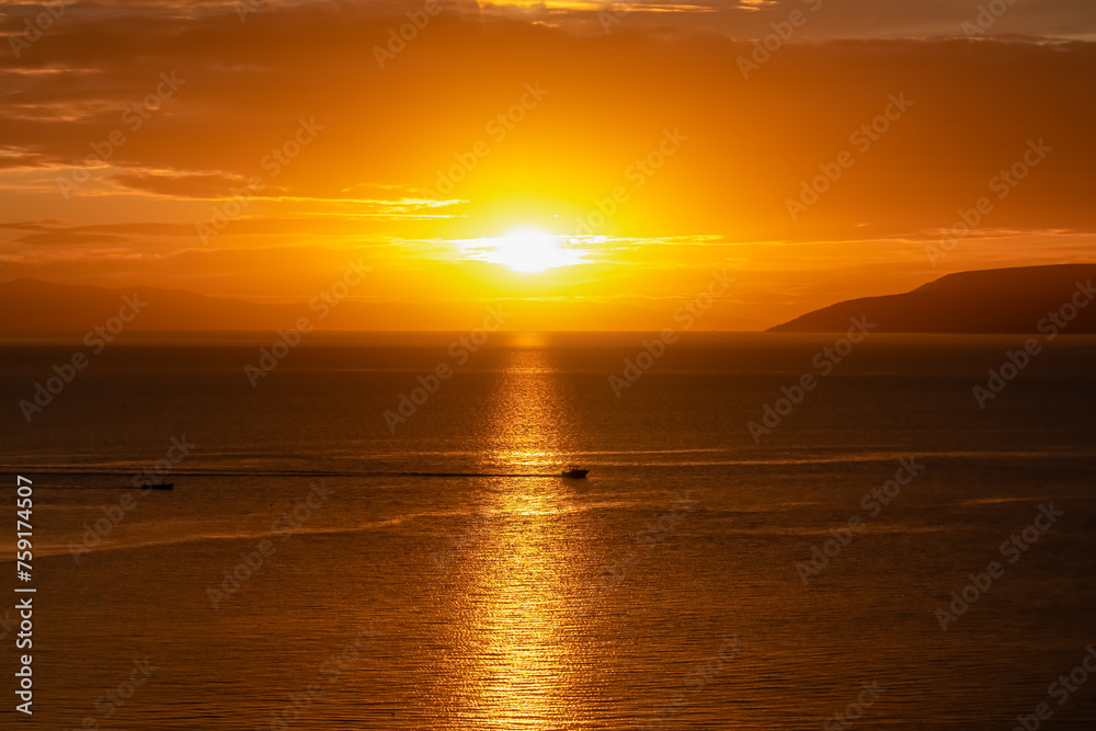 Silhouette of fishing boat with sunset view of Dalmatian archipelago seen from coastal town Makarska, Split-Dalmatia, Croatia, Europe. Coastline of Makarska Riviera, Adriatic Sea. Balkans in summer