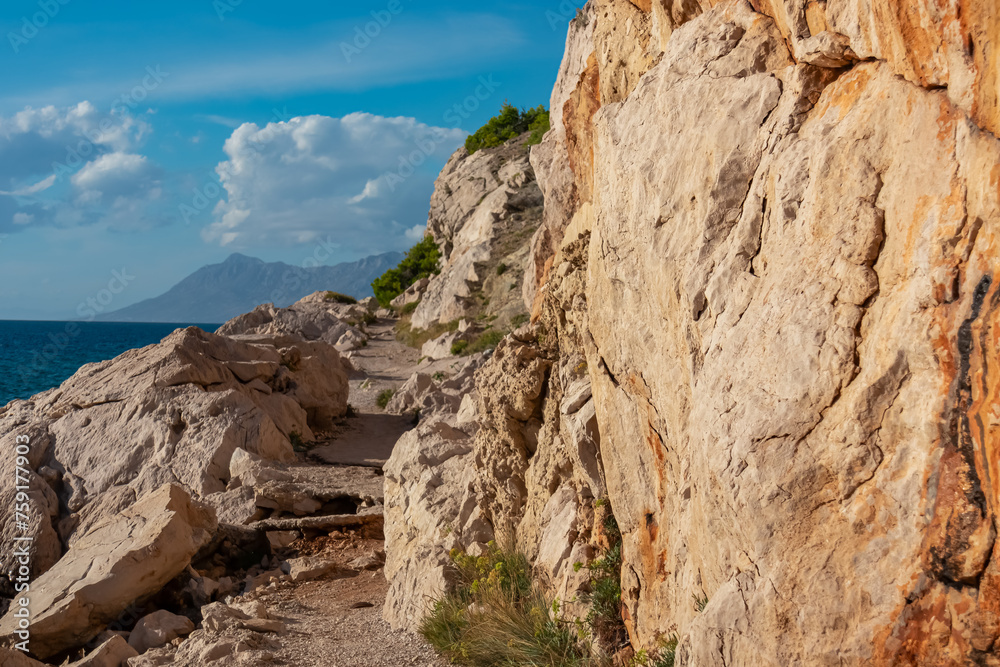 Idyllic hiking trail along steep coastal cliffs from Krvavica to Makarska, Dalmatia, Croatia, Europe. Majestic coastline of Makarska Riviera. Adriatic Sea in Balkan Peninsula in summer. Wanderlust Idyllic hiking trail along steep coastal cliffs from Krvavica to Makarska, Dalmatia, Croatia, Europe. Majestic coastline of Makarska Riviera. Adriatic Sea in Balkan Peninsula in summer. Wanderlust