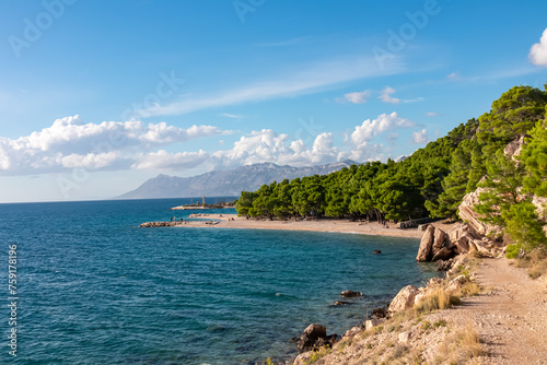 Idyllic stone beach Plaza Ramova in coastal town Krvavica, Dalmatia, South Croatia, Europe. Scenic view of majestic Makarska Riviera in Adriatic Mediterranean Sea. Mountains of Biokovo nature reserve photo