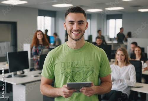 A young professional with a tablet stands in a meeting room. His green shirt and confident posture signal a creative and dynamic approach to his work. photo