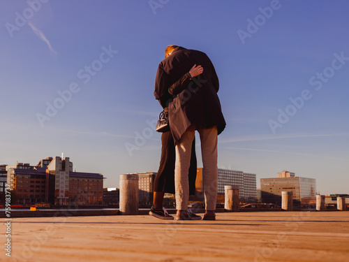 couple hugging on a wooden boulevard