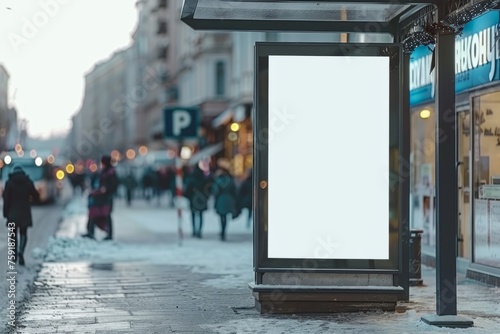 A large white billboard sits on a city street, illuminated by the streetlights. The empty billboard and bench give the impression of a quiet, peaceful moment in the city