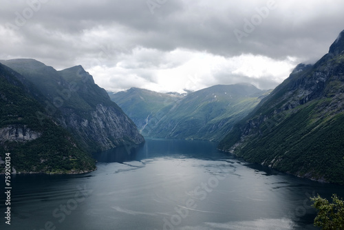 Fototapeta Naklejka Na Ścianę i Meble -  Magnificent Geirangerfjord in Norway. Fjord is surrounded by majestic mountains, covered with lush green trees, creating picturesque landscape