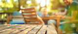 Wooden table set on a terrace against a blurred background where a father and child enjoy a leisurely summer day, symbolizing familial bonds and the warmth of spending quality time together outdoors