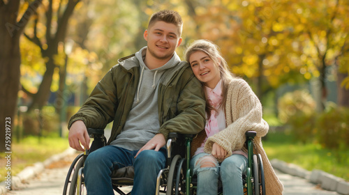 Young man in a wheelchair with his girlfriend in the autumn park. Disabled people concept.