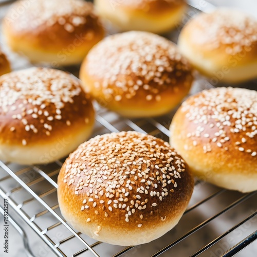 Homemade buns for burgers with sesame on white plate,marble background, closeup