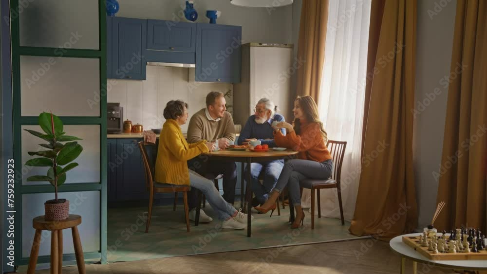 Senior lady amusing company with joke and laughing at home