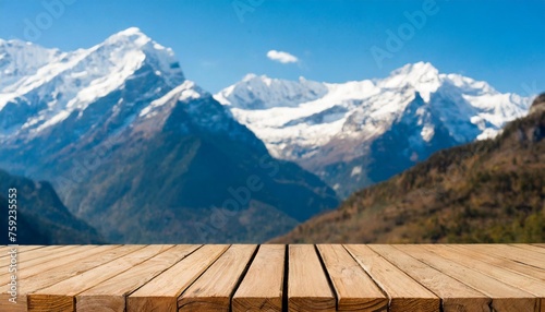 empty wooden table top with blur background of snow capped mountains © William
