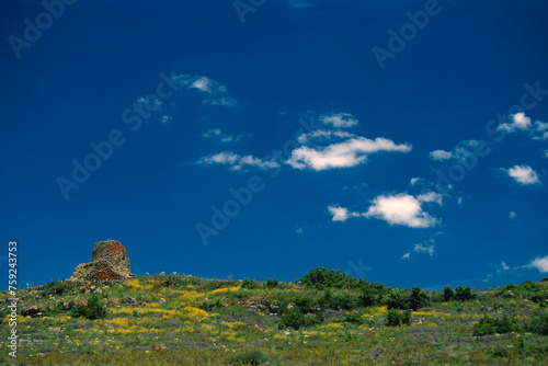 Nuraghe Santa Barbara in a colourful spring day under blue sky amd clouds, Macomer, Sardinia, Italy photo