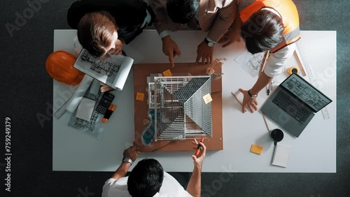 Top down aerial view of smart architect engineer team inspect house model while manager hold blueprint and asking about building construction. Group of diverse engineer working together. Alimentation. photo